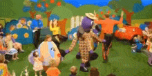 a group of children are watching a group of cartoon characters dancing in front of them .