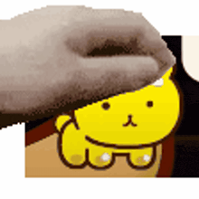a person is putting a hat on a yellow bear .