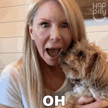 a woman is holding a small dog and says oh in front of her