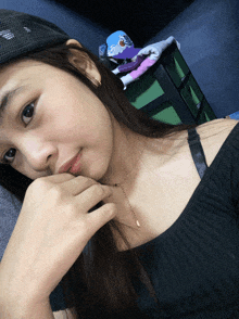 a woman wearing a hat and a necklace is laying down