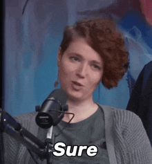 a woman sitting in front of a microphone says " yeah "