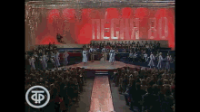 a group of people are dancing on a stage with the word techni-ru in the background