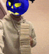 a man wearing a blue mask is holding a large stack of money