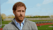 a man with a beard wears a grey jacket