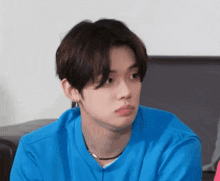 a young man wearing a blue shirt is making a face