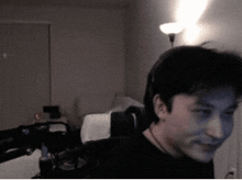 a man in a black shirt is looking at the camera