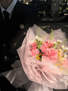 a man holding a bouquet of pink and white flowers