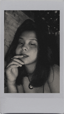 a black and white photo of a young woman smoking