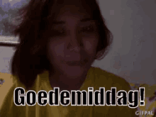 a woman in a yellow shirt says goedemiddag in a dark room