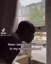 a man is standing in front of a window and talking to someone .