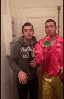 a man in a hollister shirt is standing next to another man in a pink shirt