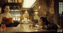 two women sitting at a bar with the word hw on the bottom right