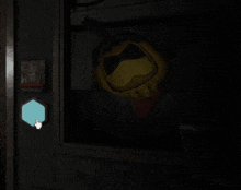 a hand is pointing at a blue circle in a dark room