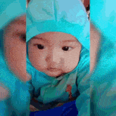 a baby with a giraffe on his shirt is wearing a blue outfit