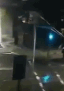 a blurry picture of a car driving down a street with a green light in the background