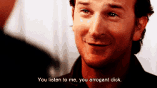 a man says " you listen to me you arrogant dick " while smiling