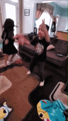 two children are dancing in a living room with one wearing a shirt that says ' i love you '
