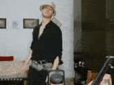 a man wearing a hat and a black shirt is standing in a living room
