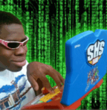 a man wearing sunglasses is typing on a shs toy