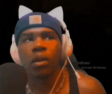 a man wearing headphones and a cat ear hat is looking at the camera .