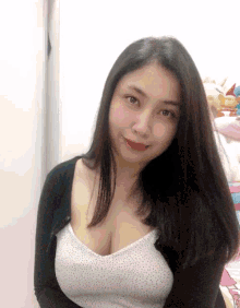 a woman wearing a black cardigan and a white tank top