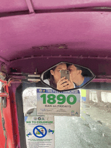a man and a woman are kissing in a car with a sign that says 1890
