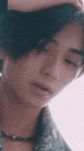 a close up of a person 's face with their hand on their forehead .