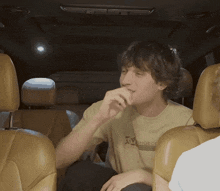 a man sitting in a car wearing a t-shirt that says shoeclub