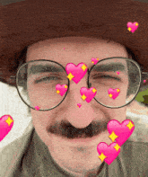 a man wearing glasses and a hat with pink hearts coming out of his eyes