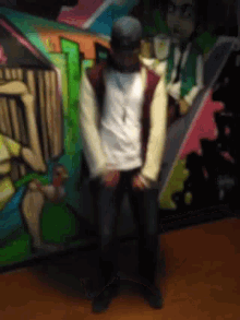 a blurry picture of a man in front of a graffiti wall