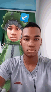 a man wearing headphones and a frog costume has a blue arrow on his head