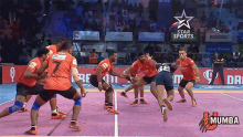 a group of men are playing a game of kabaddi in front of a star sports ad