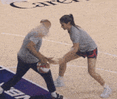 a man and a woman are playing basketball on a court that has the word career on the floor
