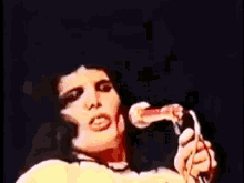a woman is singing into a microphone with her mouth wide open
