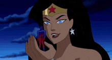 a cartoon character in a red and blue superhero costume is being held by a large hand