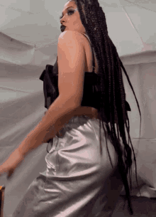 a woman with braids and a black top is dancing