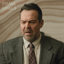 a man in a suit and tie with the words small achievable goals on the bottom