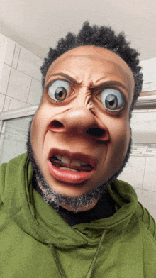 a man wearing a green hoodie has a cartoon face on his face