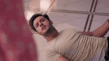 a man in a white shirt is laying on the floor with his arms outstretched