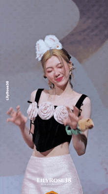 a woman wearing a black top with white flowers and a pink skirt with lilyrose38 written on the bottom