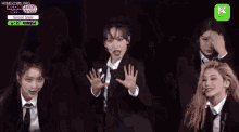 a group of women are standing next to each other on a stage wearing suits and ties .