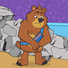 a cartoon bear with a blue belt around his waist is standing in front of rocks