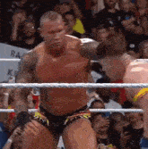 a man in a wrestling ring with a crowd behind him and a sign that says ra on it