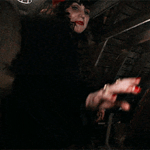 a woman wearing a red hat is smiling and pointing