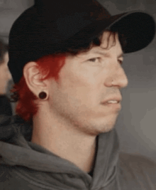 a close up of a man wearing a hat and a hoodie .