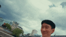 a man stands in front of a cloudy sky