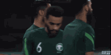 a soccer player wearing a green jersey with the number 6