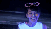 a girl with glow in the dark paint on her face and heart shaped glasses