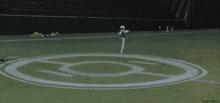 a person standing in a circle on a field with the letter o on it