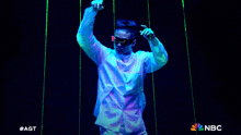 a man wearing glow in the dark glasses is dancing on a stage
